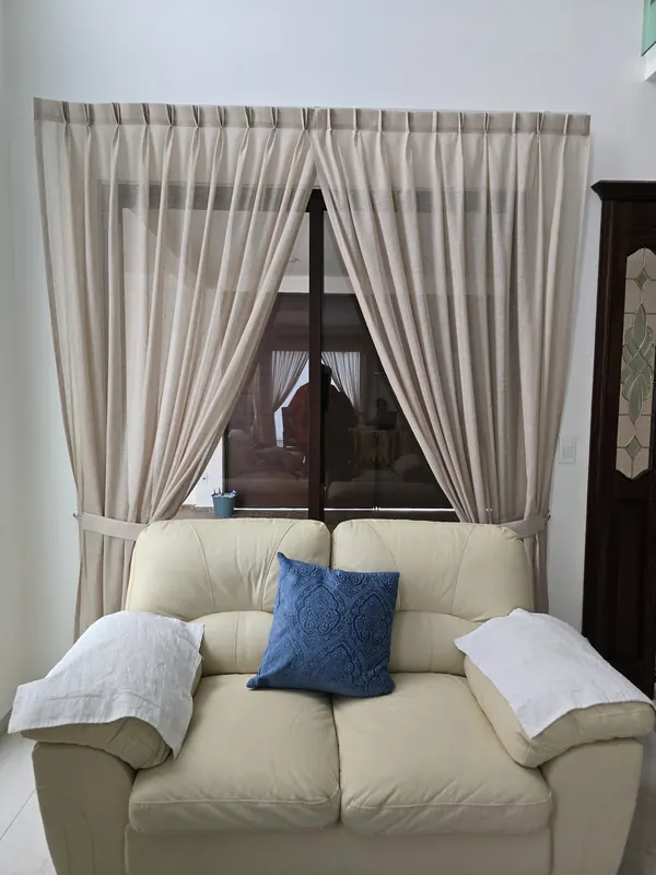 Cortinas beige recogidas con alzapaños en una sala de Puebla