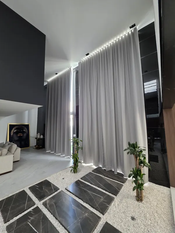 Cortinas blackout a doble altura junto a un jardín interior en Puebla