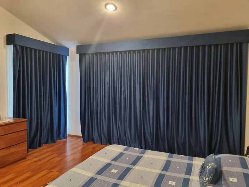Cortinas blackout azul marino con cenefa en una recámara de Puebla