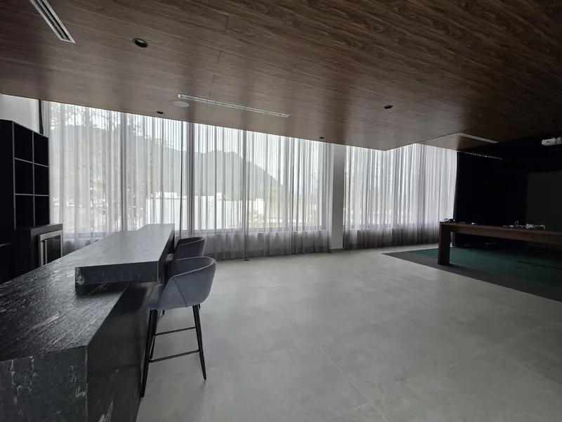 Cortinas de tergal en el ventanal de un estudio con plafón de madera en Puebla