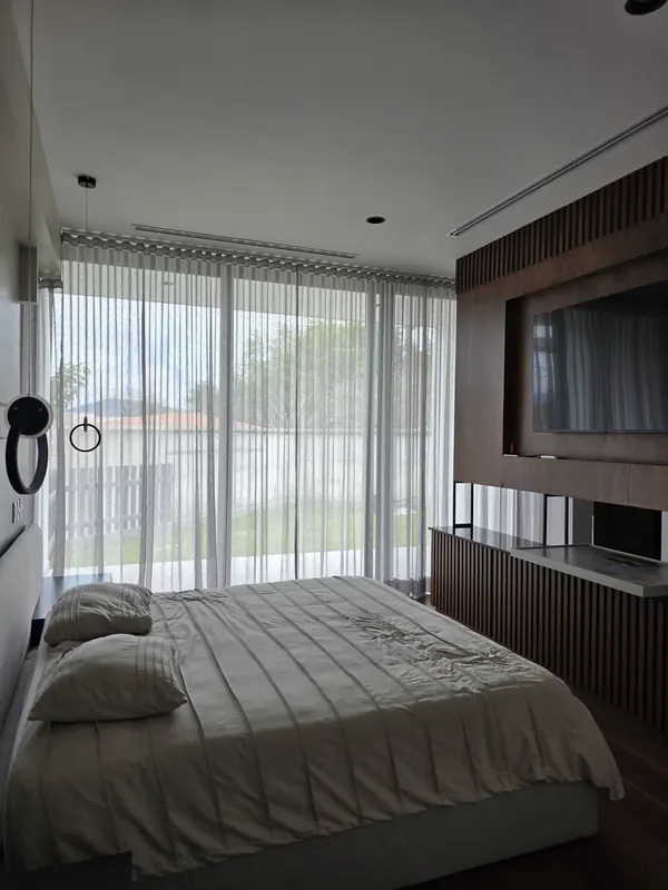 Cortina de tergal en el ventanal de una recámara con cama en Puebla