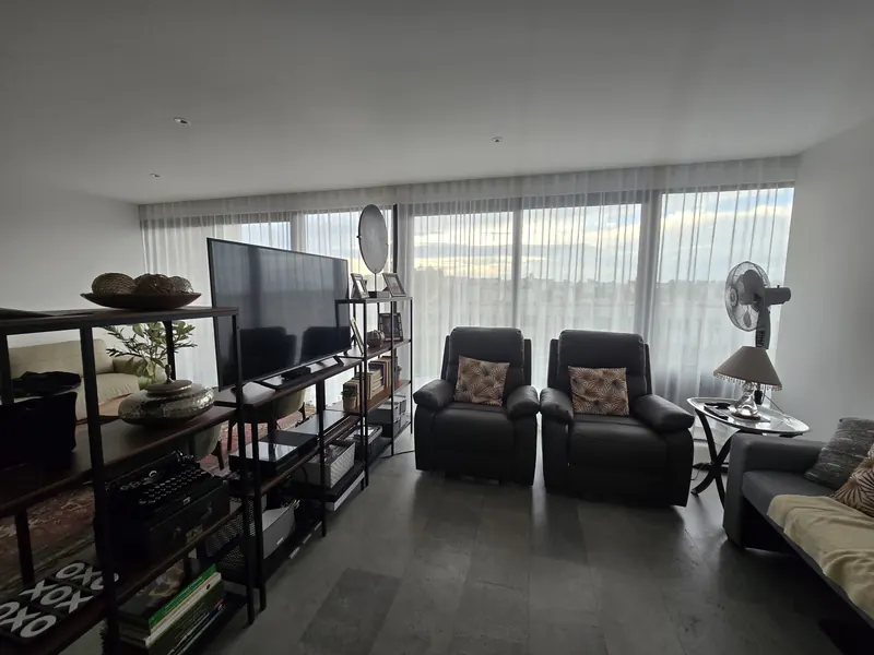 Cortinas de tergal en un ventanal panorámico de sala de TV en Puebla