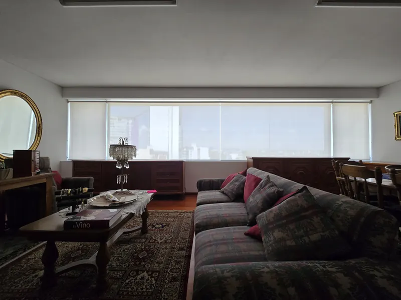Persianas de malla solar en un ventanal panorámico de sala en Puebla