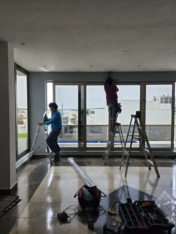 Tres instaladores de Style Coverings colocando persianas en un ventanal