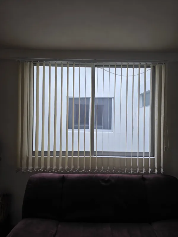 Persiana vertical de tela con las lamas giradas en una sala de Puebla