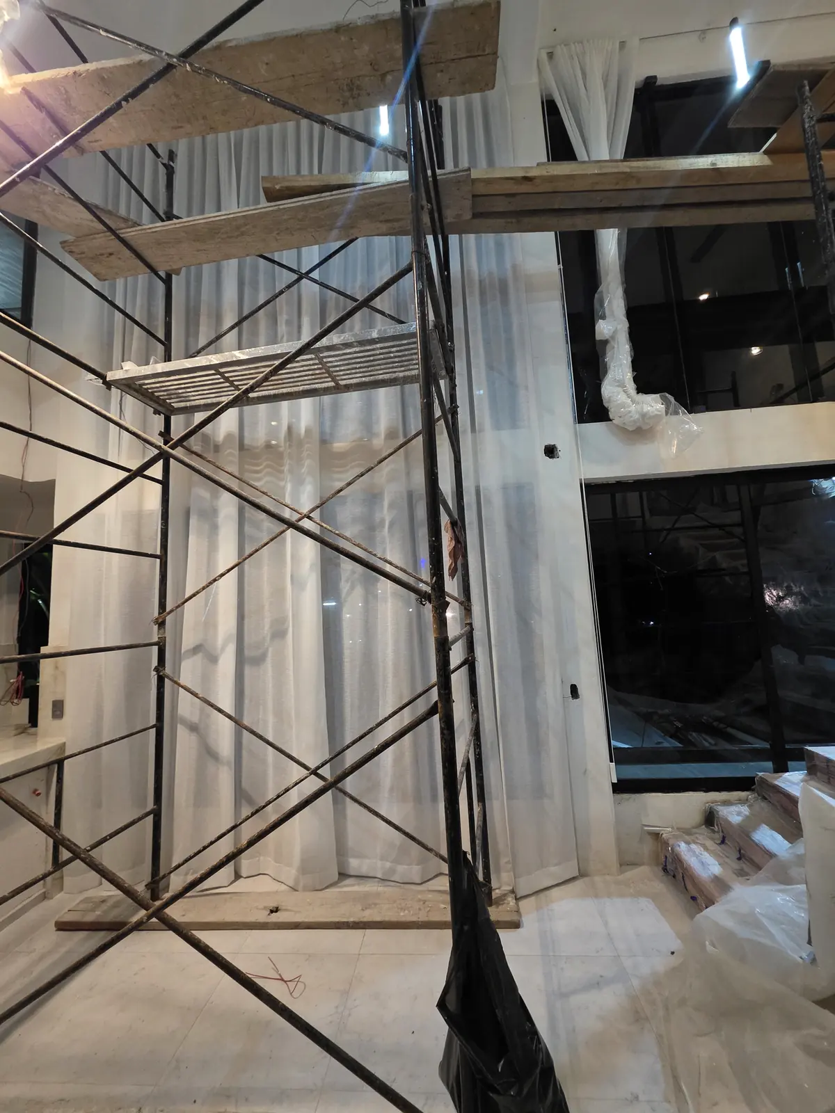 Cortina sheer a doble altura instalada con andamios en una residencia