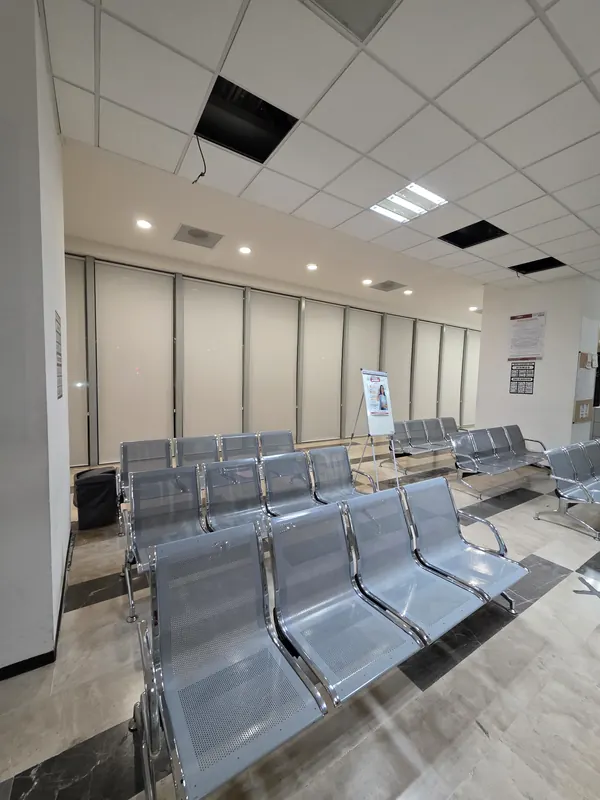 Sala de espera de una clínica con persianas de malla solar de Style Coverings