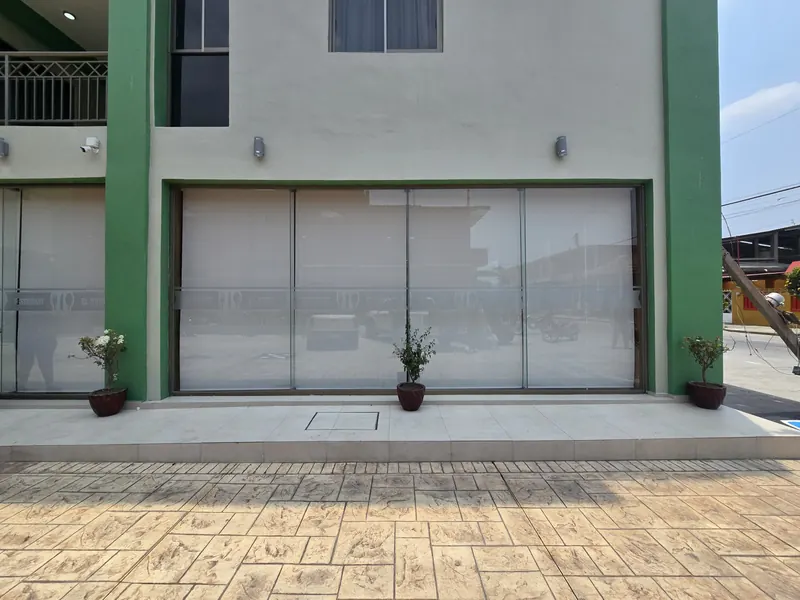 Fachada de cristal de un local comercial con malla solar de Style Coverings